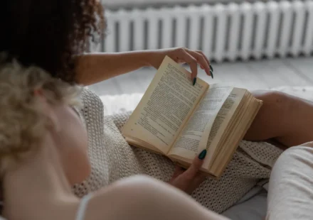A person reading a book indoors, enjoying a relaxing and cozy environment.
