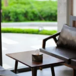 Elegant interior of a modern lounge area featuring leather sofas and a coffee table near large windows.