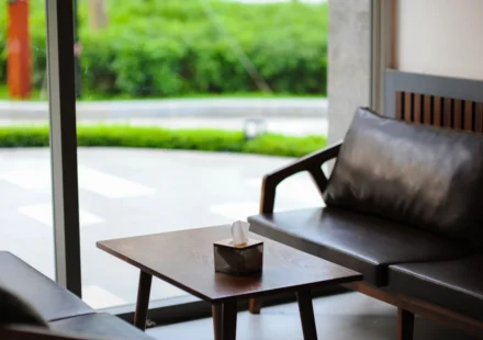Elegant interior of a modern lounge area featuring leather sofas and a coffee table near large windows.